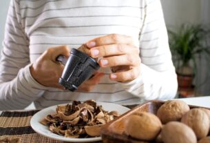 frau-knackt-walnuesse-302844815