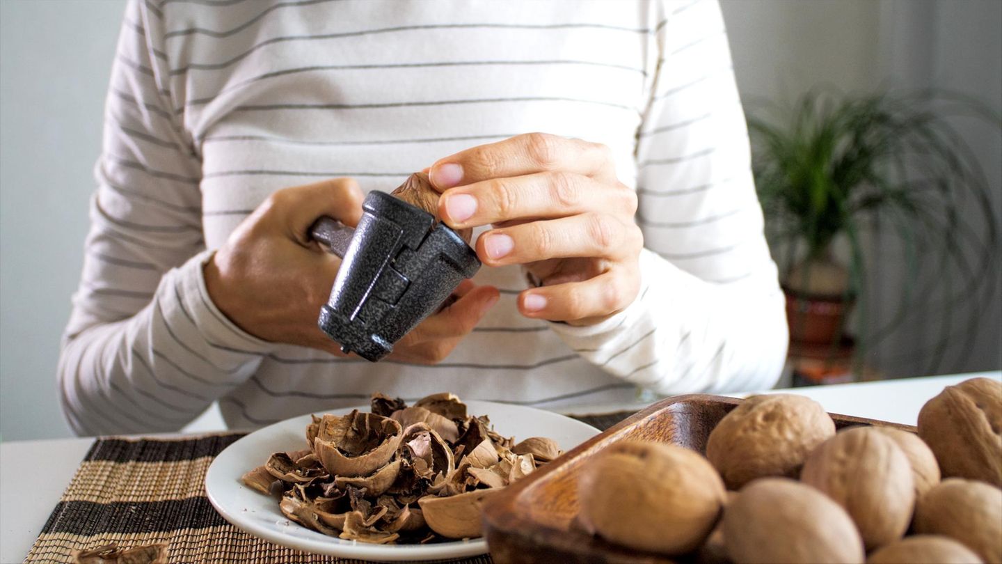 frau-knackt-walnuesse-302844815